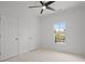 This bedroom has neutral carpet, white walls, and ceiling fan, and a large window at 404 Wade Creek Rd, Alpharetta, GA 30009