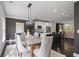 Elegant dining room features modern lighting, open to the kitchen with barstool seating, perfect for entertaining at 404 Wade Creek Rd, Alpharetta, GA 30009