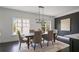 Bright dining area featuring a modern chandelier, neutral walls, and a view to outside greenery through large windows at 404 Wade Creek Rd, Alpharetta, GA 30009