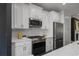 Well-appointed kitchen showcasing stainless steel appliances, crisp white cabinetry and patterned tile backsplash at 404 Wade Creek Rd, Alpharetta, GA 30009