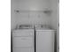 Bright laundry room with modern washer and dryer, plus overhead wire shelving for storage at 404 Wade Creek Rd, Alpharetta, GA 30009