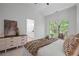 Bright main bedroom featuring a plush bed, window view, and dresser; with a glimpse into the attached bathroom at 404 Wade Creek Rd, Alpharetta, GA 30009