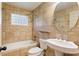 Bathroom with a bathtub, ceramic tile, and pedestal sink at 975 Shirley Se St, Smyrna, GA 30082