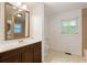Bathroom with dark wood vanity, mirror, tile floor, and window at 975 Shirley Se St, Smyrna, GA 30082