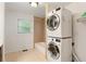 Tiled bathroom with a shower over tub, window and a practical stacked washer and dryer unit at 975 Shirley Se St, Smyrna, GA 30082