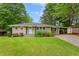 Charming single-story home with a well-manicured lawn, mature trees, and a quaint light-blue front door at 975 Shirley Se St, Smyrna, GA 30082