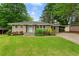 Charming single-story home with a well-manicured lawn, mature trees, and a quaint light-blue front door at 975 Shirley Se St, Smyrna, GA 30082