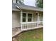 Exterior view of a home with light siding and a white, small porch, plus green foliage in the yard at 2919 Cushing Ct, Jonesboro, GA 30238