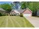 Charming single-story home featuring a brick facade, two-car garage, and a well-manicured lawn with mature trees at 2880 Cressington Nw Bnd, Kennesaw, GA 30144