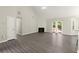 Open-concept living room featuring high ceilings, fireplace, gray wood floors, and bright natural light at 2880 Cressington Nw Bnd, Kennesaw, GA 30144