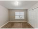 A bright bedroom features a window, closet, neutral walls, and neutral carpeting at 51 Legend Creek Way, Douglasville, GA 30134
