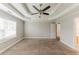 A light and airy bedroom features a tray ceiling with fan, a window and neutral carpeting at 51 Legend Creek Way, Douglasville, GA 30134
