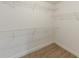 A simple walk-in closet features built-in shelves and neutral carpeting at 51 Legend Creek Way, Douglasville, GA 30134