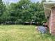 The backyard has mature trees and an AC unit; a satellite dish is visible near the brick wall at 6192 Meadowbrook Dr, Norcross, GA 30093