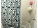 Bathroom with tiled tub and shower featuring a decorative shower curtain and pink and white bath accessories at 6192 Meadowbrook Dr, Norcross, GA 30093