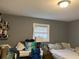 A bedroom features a gray wall, bed, desk, window, lamp, and shelves at 6192 Meadowbrook Dr, Norcross, GA 30093
