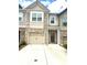 Charming townhome showcasing brick accents, a one-car garage, and a welcoming front entrance at 6318 Scudders Dr, Lithonia, GA 30058