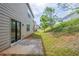 A small patio area featuring a door to the home and a sloped back yard at 1003 Eldon Ln, Fairburn, GA 30213