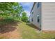 Green grass in backyard featuring a sloped landscape and back of house at 1003 Eldon Ln, Fairburn, GA 30213