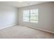 An empty bedroom featuring neutral walls, carpeted floors and natural light from a window at 1003 Eldon Ln, Fairburn, GA 30213
