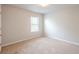 An empty bedroom featuring neutral walls, carpeted floors and natural light from a window at 1003 Eldon Ln, Fairburn, GA 30213
