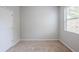 Neutral bedroom featuring carpet floors, a window with blinds, and a white door at 1003 Eldon Ln, Fairburn, GA 30213