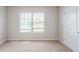 Bedroom featuring neutral walls, carpeted floors, and natural light from a window at 1003 Eldon Ln, Fairburn, GA 30213