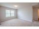 An empty bedroom has neutral walls, carpeted floors and natural light from a window at 1003 Eldon Ln, Fairburn, GA 30213