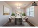 Virtually staged dining room features hardwood floors, stylish chandelier, and a marble top dining table at 1003 Eldon Ln, Fairburn, GA 30213
