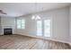 Bright living room with wood floors, a fireplace, and a modern light fixture at 1003 Eldon Ln, Fairburn, GA 30213