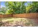 Large backyard featuring a wooden fence, lawn, and mature trees at 2294 Hill Nw St, Atlanta, GA 30318