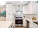 Modern kitchen with stainless steel oven and range hood, subway tile backsplash and white cabinets at 2294 Hill Nw St, Atlanta, GA 30318