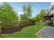 Landscaped backyard with green grass, mulched beds, and wooden fence at 280 Lakestone Pkwy, Woodstock, GA 30188