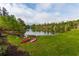 Community lake view featuring two pink kayaks by the grassy lawn and water's edge at 280 Lakestone Pkwy, Woodstock, GA 30188