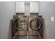 Laundry room with large capacity washer and dryer and two cabinets above at 280 Lakestone Pkwy, Woodstock, GA 30188