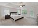Bright main bedroom features tray ceilings, neutral carpet, and windows overlooking trees at 280 Lakestone Pkwy, Woodstock, GA 30188