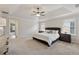 Bright main bedroom features tray ceilings, neutral carpet, and windows overlooking trees at 280 Lakestone Pkwy, Woodstock, GA 30188