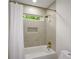 Cozy bathroom with a shower-tub combo, white tile and a small window above at 4328 Alison Jane Ne Dr, Kennesaw, GA 30144
