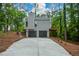 Home featuring a two-car garage, neutral siding, and a wooden deck, blending with its wooded surroundings at 4328 Alison Jane Ne Dr, Kennesaw, GA 30144