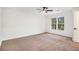 A spacious bedroom has carpet, a ceiling fan, and a window that offers ample natural light at 450 High Creek Trce, Roswell, GA 30076