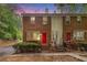 Charming townhome with a bright red door, surrounded by lush greenery and a well-maintained lawn at 450 High Creek Trce, Roswell, GA 30076