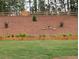 Landscaped back yard featuring a grassy area, wood retaining wall, and fenced hill with a gate at 516 Barnwood Dr, Rockmart, GA 30153
