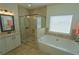 Bright bathroom featuring a glass shower, soaking tub, modern fixtures and white cabinetry at 516 Barnwood Dr, Rockmart, GA 30153