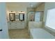 Bright bathroom featuring a glass shower, soaking tub, modern fixtures, double vanity, and tile floors at 516 Barnwood Dr, Rockmart, GA 30153