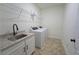 Functional laundry room with modern appliances, utility sink, storage space and tile floors at 516 Barnwood Dr, Rockmart, GA 30153