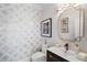 A stylish powder room with a decorative wall, sink, and gold-framed mirror at 1015 Bedford Gardens Dr, Alpharetta, GA 30022