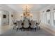 Elegant dining room with large windows, decorative chandelier, and seating for eight at 1015 Bedford Gardens Dr, Alpharetta, GA 30022