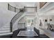 Grand foyer features a curved staircase, black marble floors, and access to other rooms at 1015 Bedford Gardens Dr, Alpharetta, GA 30022