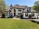 Beautiful home exterior with manicured lawn, elegant entryway, and classic architectural details at 1015 Bedford Gardens Dr, Alpharetta, GA 30022