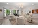Elegant living room with French doors to the porch, chic lighting, and plenty of natural light at 1015 Bedford Gardens Dr, Alpharetta, GA 30022
